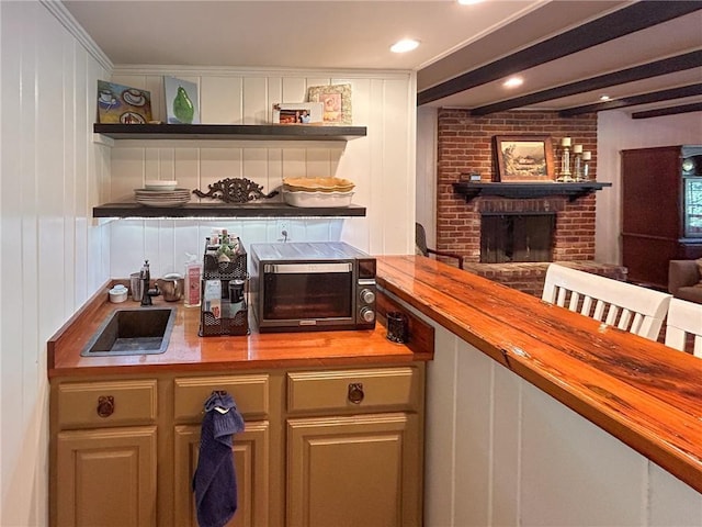bar featuring beam ceiling, a decorative wall, a brick fireplace, and a sink