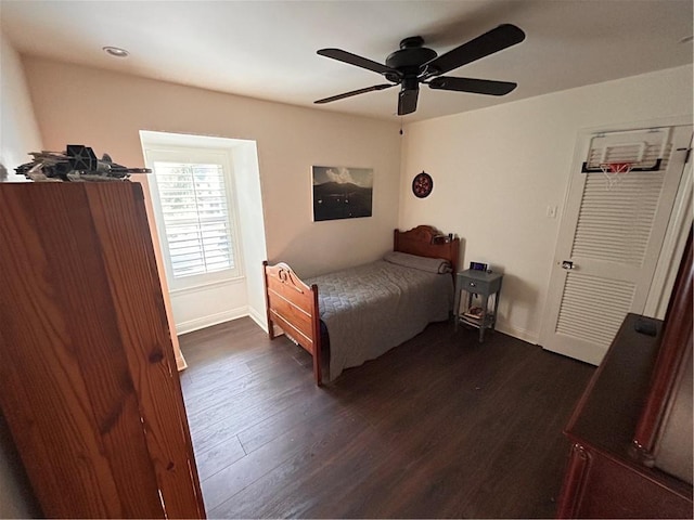 bedroom featuring dark wood-style flooring, ceiling fan, and baseboards