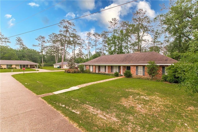 single story home featuring brick siding and a front lawn
