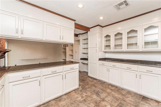 kitchen featuring a textured ceiling, white cabinetry, crown molding, open shelves, and visible vents