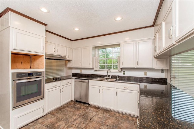 kitchen featuring white cabinetry, a sink, appliances with stainless steel finishes, under cabinet range hood, and ornamental molding