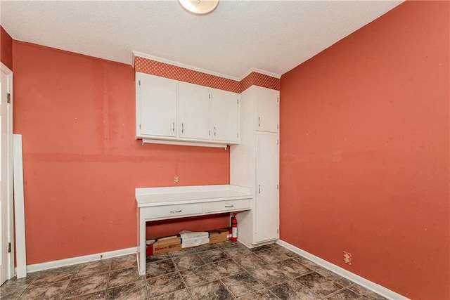interior space with baseboards and a textured ceiling