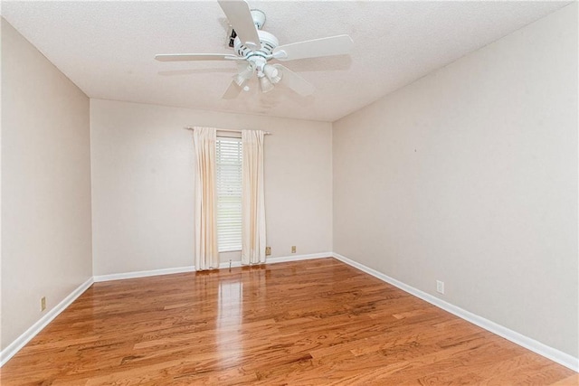 unfurnished room featuring a textured ceiling, ceiling fan, light wood-style flooring, and baseboards
