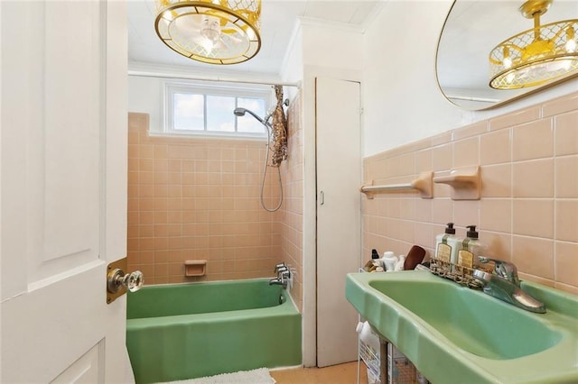 full bath with crown molding, tile walls, a sink, and shower / bath combination