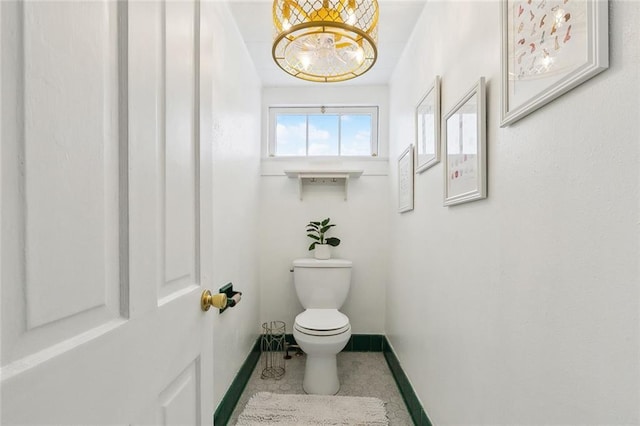 bathroom featuring baseboards, tile patterned floors, and toilet