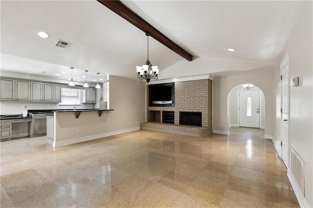 unfurnished living room featuring a notable chandelier, baseboards, visible vents, and granite finish floor