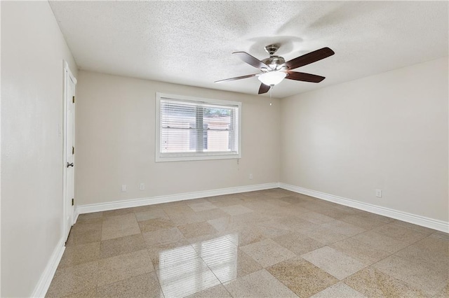 spare room with a textured ceiling, baseboards, and ceiling fan