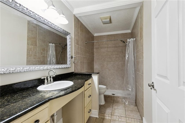 full bath featuring crown molding, vanity, toilet, a textured ceiling, and tiled shower