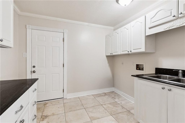 washroom with ornamental molding, baseboards, a sink, cabinet space, and washer hookup