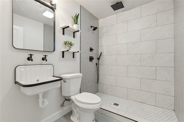 1400 Hancock St, Gretna, LA 70053 - full bathroom featuring toilet, tiled shower, and baseboards