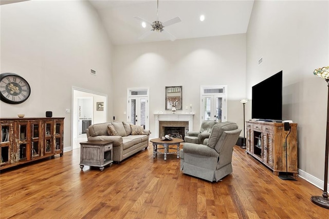 201 Laurel Ct, Luling, LA 70070 - living room featuring visible vents, hardwood / wood-style floors, a fireplace, high vaulted ceiling, and a ceiling fan