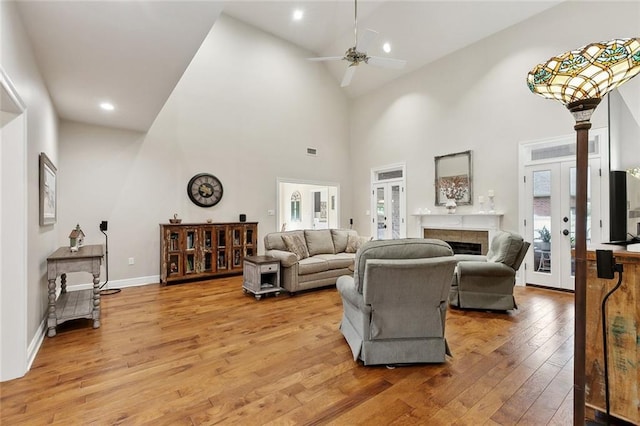 201 Laurel Ct, Luling, LA 70070 - living room featuring light wood-style flooring, a fireplace, high vaulted ceiling, a ceiling fan, and french doors