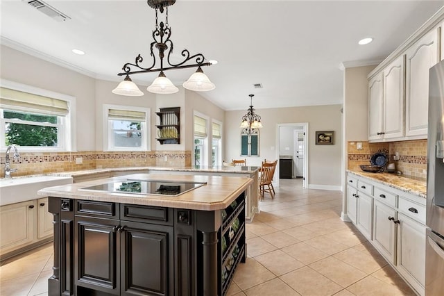 201 Laurel Ct, Luling, LA 70070 - kitchen with a sink, visible vents, light tile patterned flooring, black electric cooktop, and backsplash