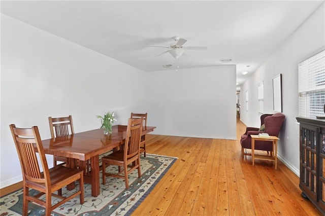 dining space with visible vents, light wood-type flooring, and a ceiling fan