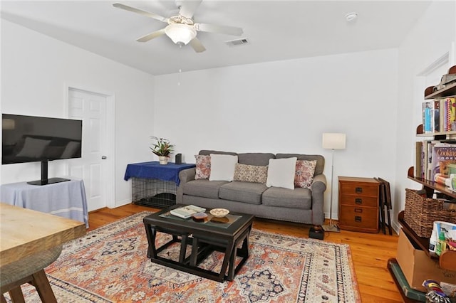 living area with visible vents, a ceiling fan, and light wood finished floors
