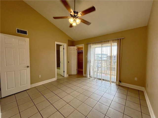 unfurnished bedroom with light tile patterned floors, visible vents, vaulted ceiling, and baseboards