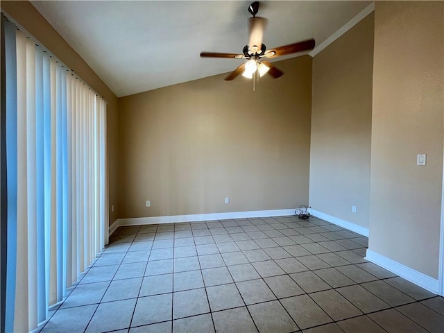 spare room featuring lofted ceiling, light tile patterned flooring, a ceiling fan, and baseboards