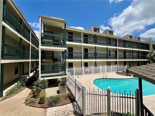 community pool with a patio and fence