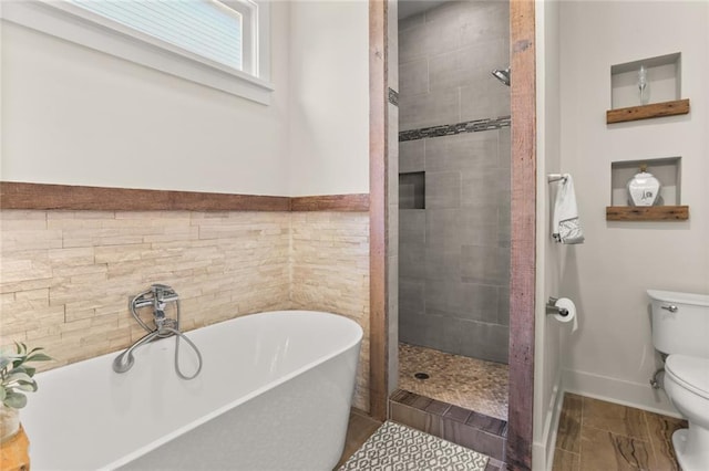 bathroom featuring toilet, a freestanding bath, and tiled shower