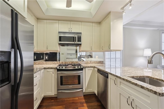 kitchen featuring a sink, dark wood-type flooring, crown molding, light stone counters, and appliances with stainless steel finishes