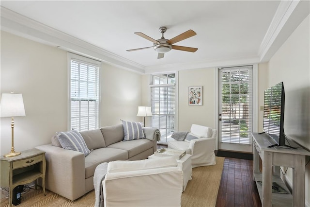living area featuring a wealth of natural light, hardwood / wood-style flooring, ceiling fan, and crown molding