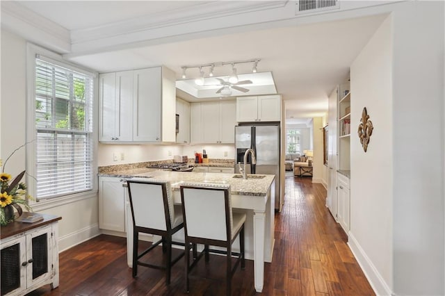 kitchen featuring ceiling fan, visible vents, baseboards, light stone countertops, and dark wood finished floors
