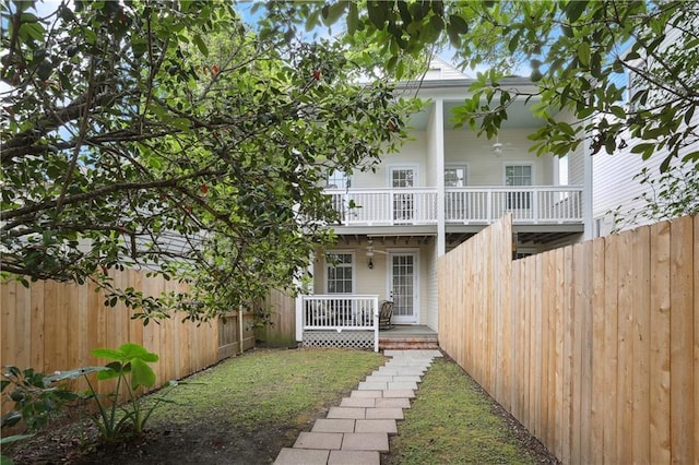 back of property with fence and a porch