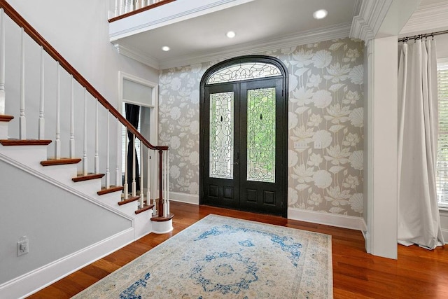 entrance foyer with stairway, baseboards, and wallpapered walls