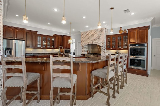 kitchen featuring crown molding, appliances with stainless steel finishes, glass insert cabinets, a breakfast bar, and recessed lighting