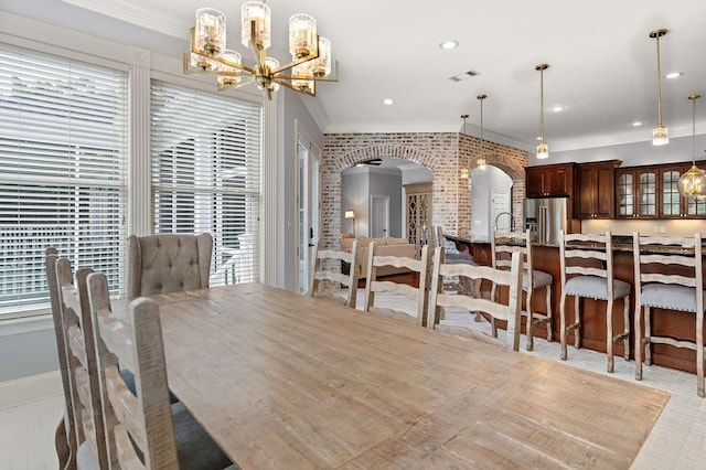 dining area with visible vents, arched walkways, a chandelier, ornamental molding, and recessed lighting