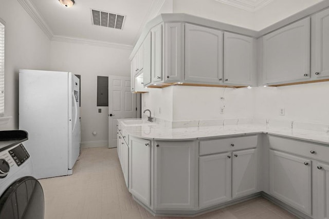 kitchen with washer / clothes dryer, visible vents, a sink, freestanding refrigerator, and ornamental molding