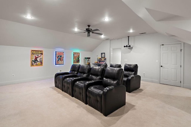 home theater with ceiling fan, light colored carpet, baseboards, and vaulted ceiling