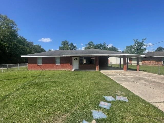 ranch-style home with fence, a carport, a front yard, and concrete driveway