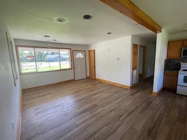 unfurnished living room with baseboards and dark wood-style flooring