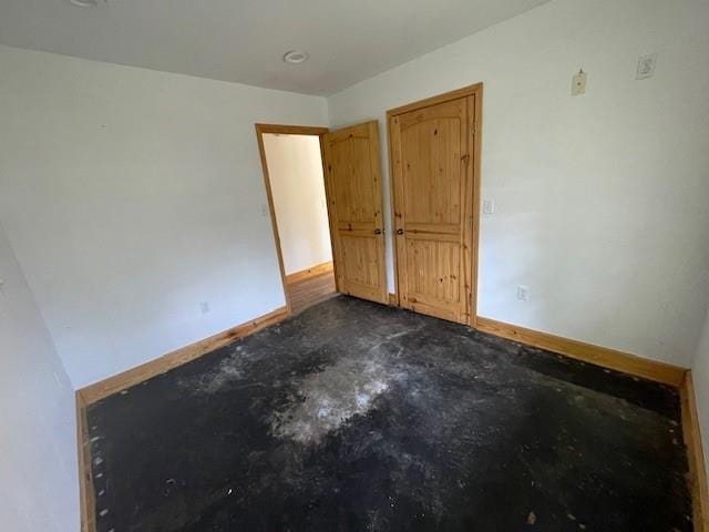 empty room featuring concrete floors and baseboards