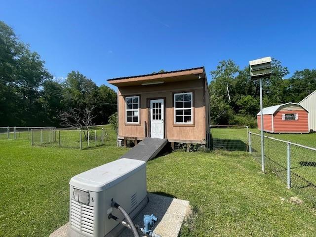 view of outdoor structure featuring fence and an outbuilding