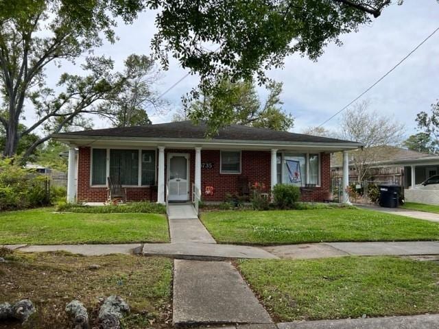 6735 W Magnolia Blvd, Harahan, LA 70123 - view of front of house featuring brick siding and a front lawn