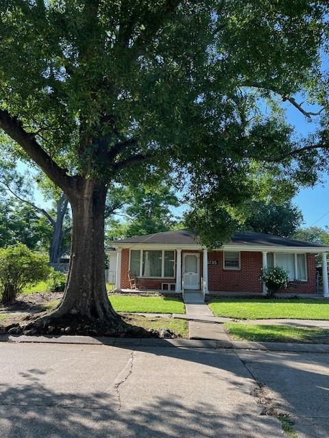 6735 W Magnolia Blvd, Harahan, LA 70123 - view of front of property with brick siding and a front lawn