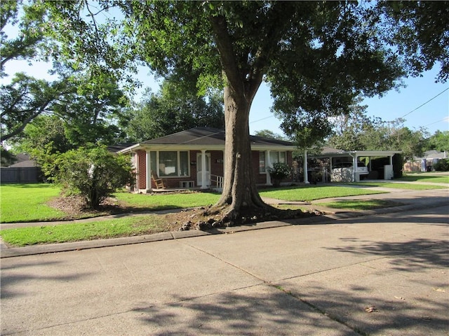 6735 W Magnolia Blvd, Harahan, LA 70123 - single story home with an attached carport, concrete driveway, and a front lawn