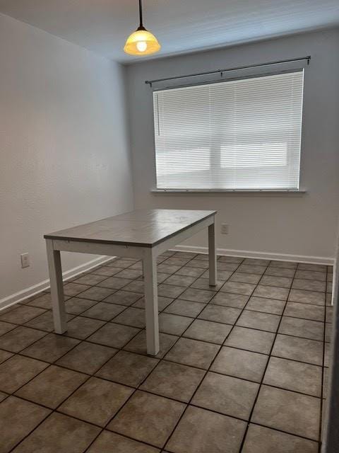 unfurnished dining area featuring light tile patterned floors and baseboards