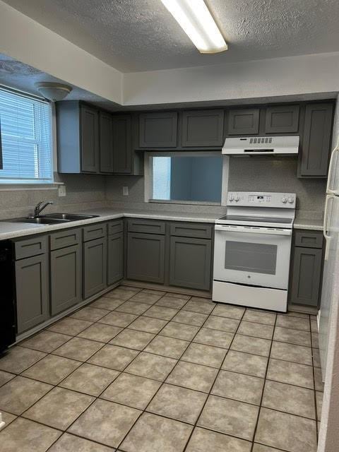 kitchen with white range with electric stovetop, light countertops, gray cabinets, and under cabinet range hood