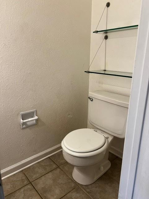 bathroom featuring tile patterned floors, baseboards, and toilet