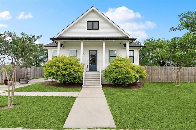2321 Mehle St, Arabi, LA 70032 - bungalow-style house with covered porch, fence, and a front lawn