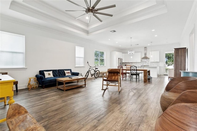 2321 Mehle St, Arabi, LA 70032 - living room with wood finished floors, a wealth of natural light, ornamental molding, and a tray ceiling