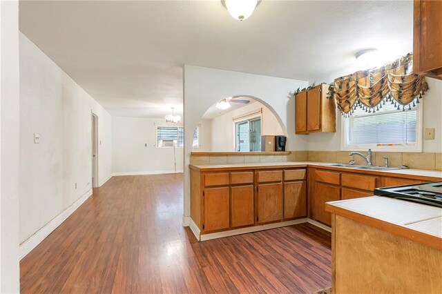 2751 Washington Ave, Slidell, LA 70458 - kitchen with a sink, brown cabinets, dark wood finished floors, light countertops, and a chandelier