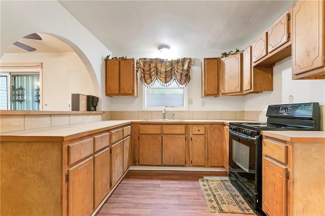 2751 Washington Ave, Slidell, LA 70458 - kitchen featuring black electric range oven, a peninsula, a sink, dark wood-style floors, and light countertops