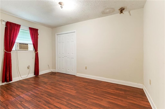 2751 Washington Ave, Slidell, LA 70458 - unfurnished bedroom with wood finished floors, baseboards, a textured ceiling, and cooling unit