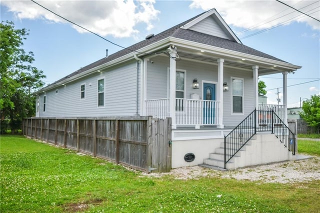 4132 Martin Luther King Jr Blvd, New Orleans, LA 70125 - view of front facade with covered porch, a shingled roof, a front lawn, and stairs
