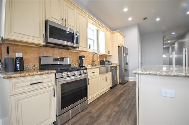 4132 Martin Luther King Jr Blvd, New Orleans, LA 70125 - kitchen with tasteful backsplash, stainless steel appliances, cream cabinets, and dark wood-type flooring