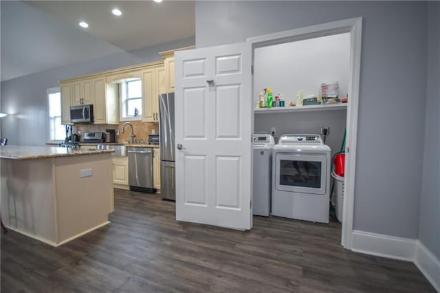 4132 Martin Luther King Jr Blvd, New Orleans, LA 70125 - kitchen with independent washer and dryer, stainless steel appliances, cream cabinetry, recessed lighting, and dark wood-type flooring